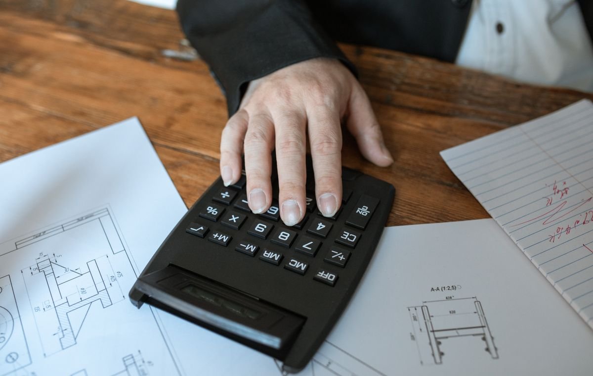 Mesa com calculadora e documentos durante a análise de uma dívida