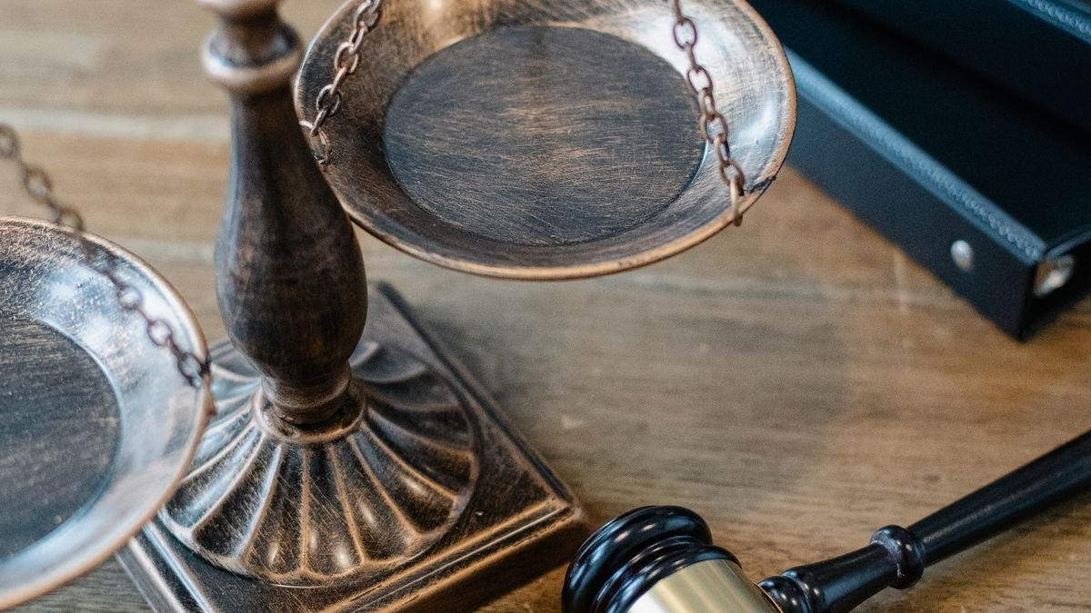 Balança da justiça e martelo sobre a mesa